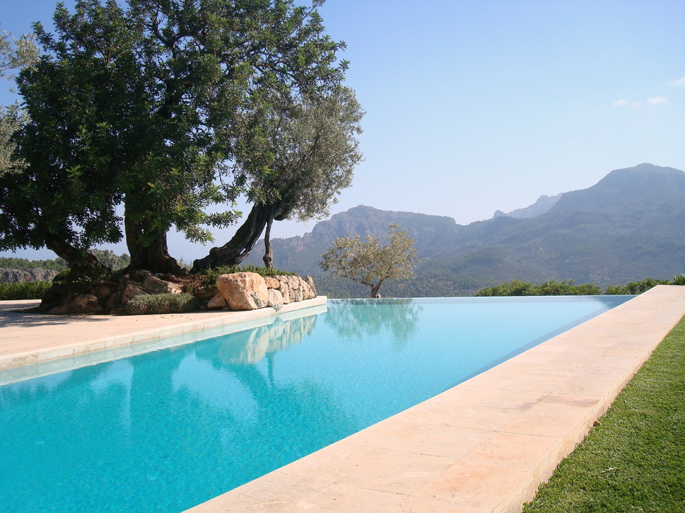 Immagine di una piscina a sfioro infinito mediterranea rettangolare di medie dimensioni con una dépendance a bordo piscina