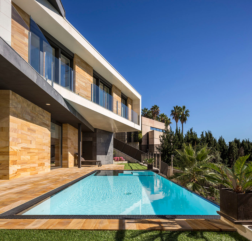 Foto de casa de la piscina y piscina infinita actual de tamaño medio rectangular en patio trasero