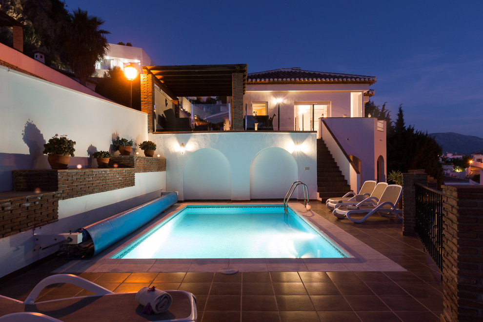 Modelo de piscina alargada mediterránea grande rectangular con adoquines de piedra natural