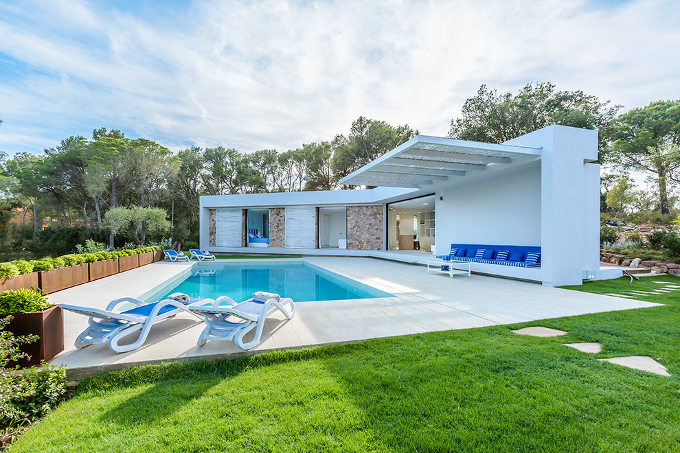 Immagine di una piscina mediterranea rettangolare dietro casa e di medie dimensioni con piastrelle