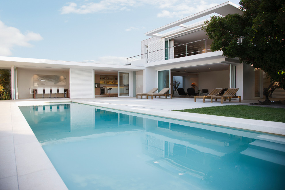 Ejemplo de piscina alargada mediterránea grande rectangular en patio delantero con suelo de baldosas