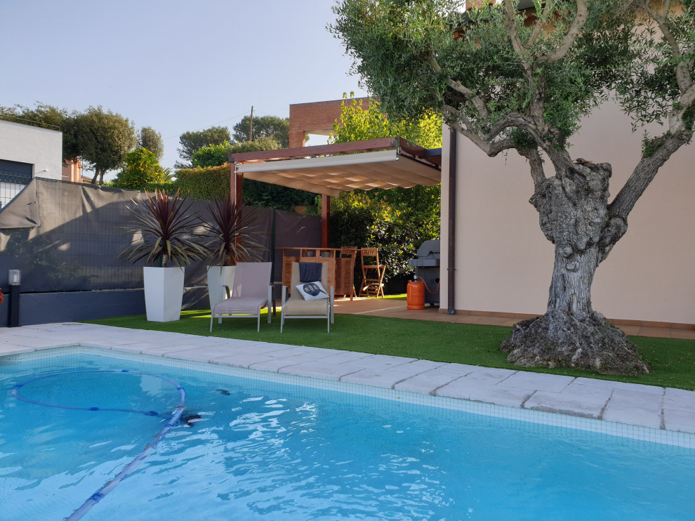 Immagine di una grande piscina monocorsia mediterranea rettangolare davanti casa con pavimentazioni in cemento