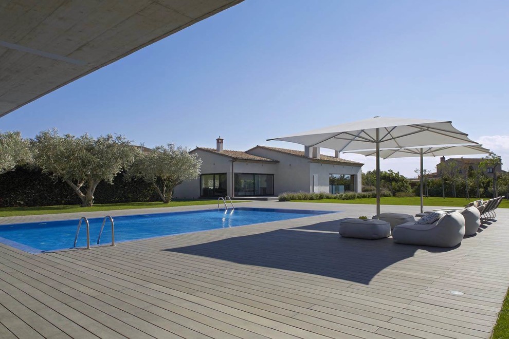 Modelo de casa de la piscina y piscina alargada campestre de tamaño medio rectangular en patio delantero con entablado