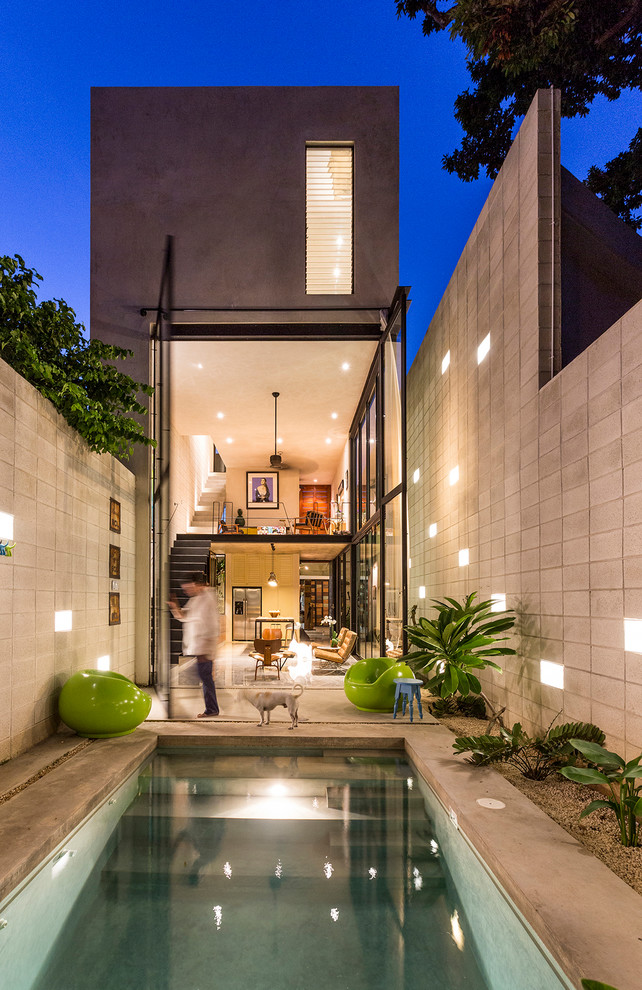 Moderner Pool hinter dem Haus in rechteckiger Form mit Betonplatten in Mexiko Stadt