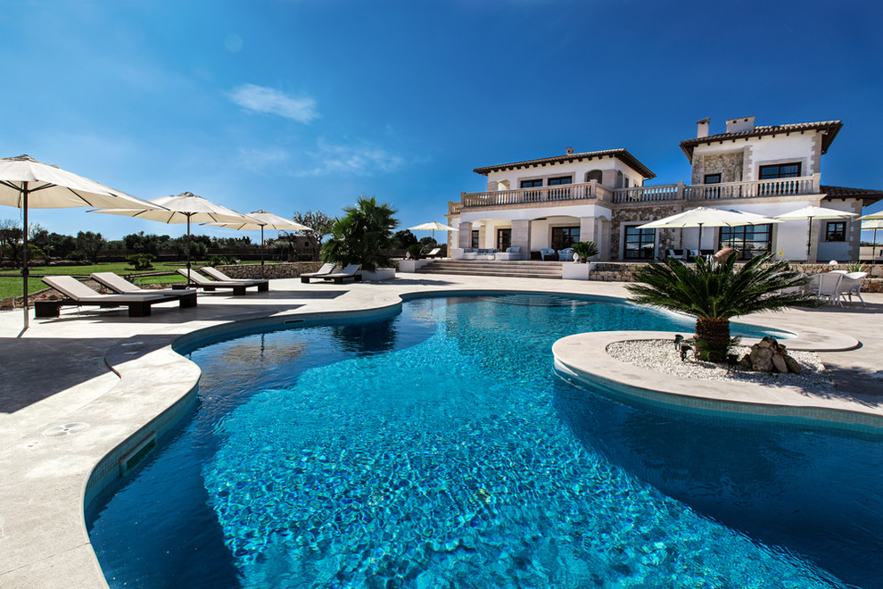 Ejemplo de casa de la piscina y piscina alargada mediterránea grande a medida con adoquines de piedra natural