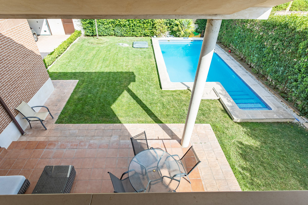 Ejemplo de casa de la piscina y piscina alargada minimalista pequeña rectangular en patio con adoquines de hormigón