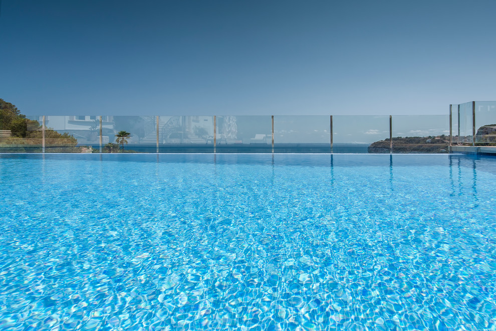 Idée de décoration pour une grande piscine méditerranéenne rectangle.
