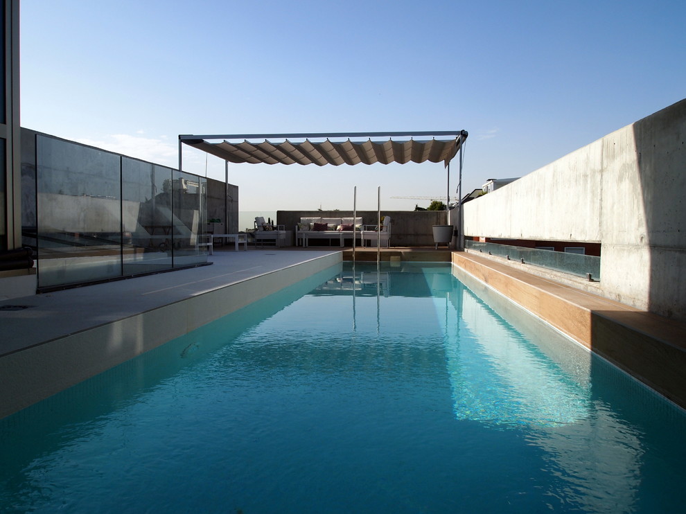 Diseño de piscina alargada minimalista de tamaño medio rectangular en azotea con suelo de baldosas
