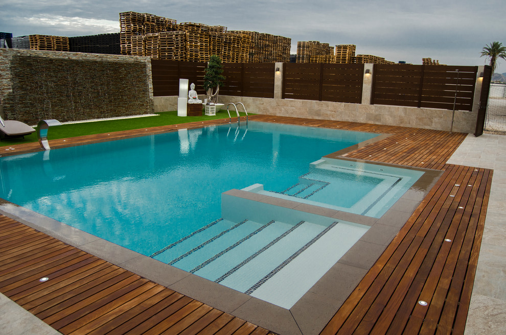 Esempio di una grande piscina minimalista rettangolare con una vasca idromassaggio