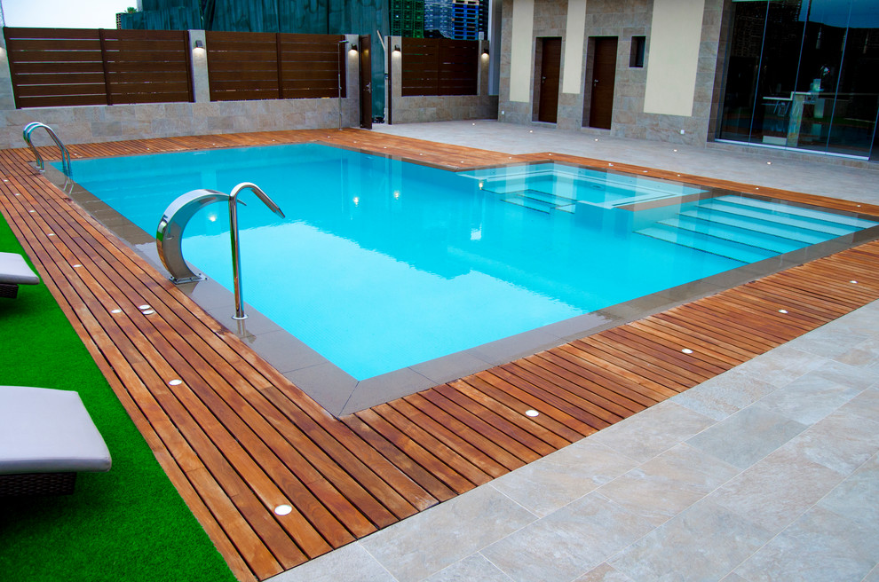 Esempio di una grande piscina minimalista rettangolare con una vasca idromassaggio