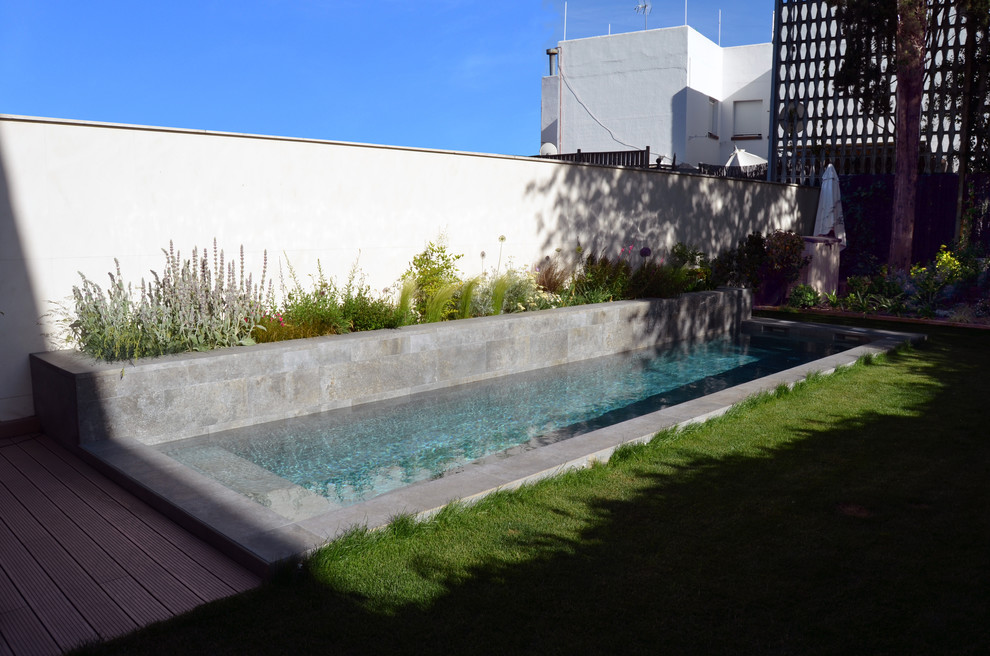 Foto de piscina alargada actual grande rectangular en patio trasero