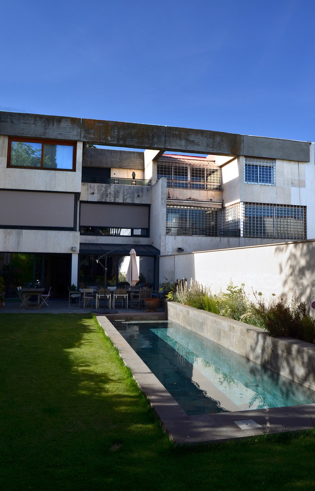 Foto de piscina alargada contemporánea grande rectangular en patio trasero