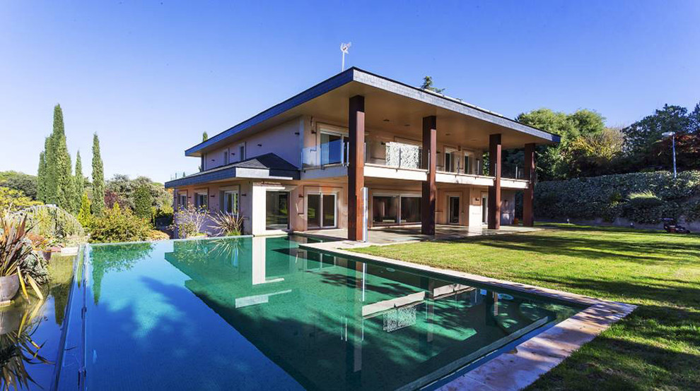 Modelo de casa de la piscina y piscina infinita tradicional renovada de tamaño medio a medida en patio lateral