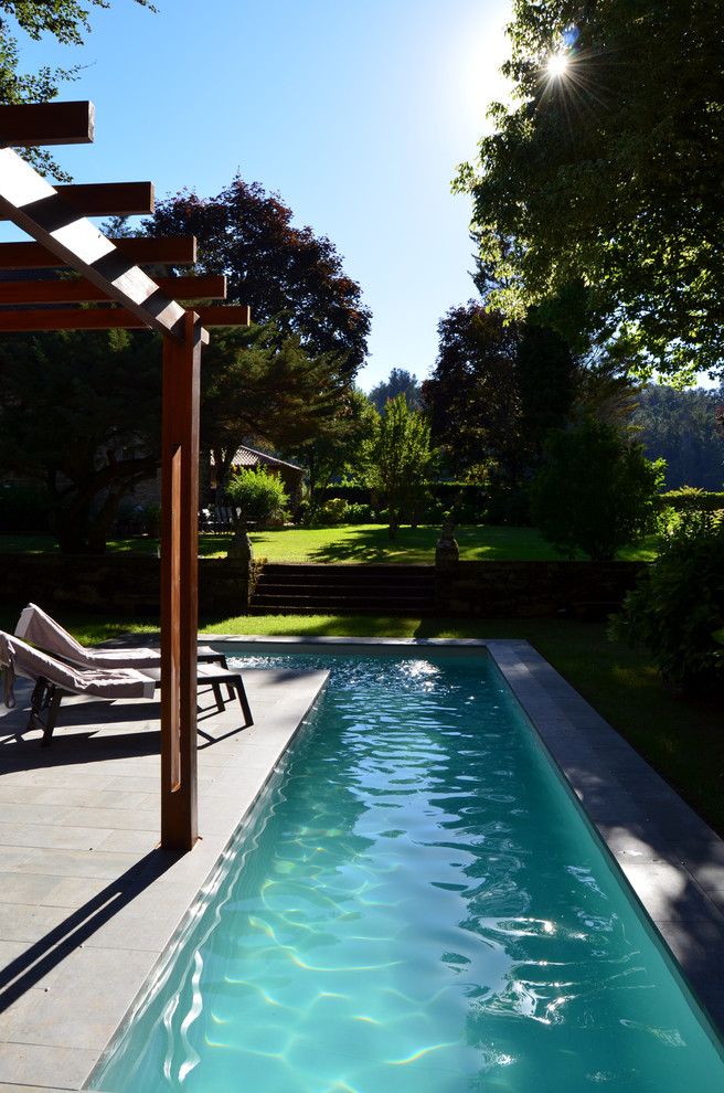 Идея дизайна: спортивный, угловой бассейн среднего размера на заднем дворе в стиле кантри с домиком у бассейна и покрытием из плитки