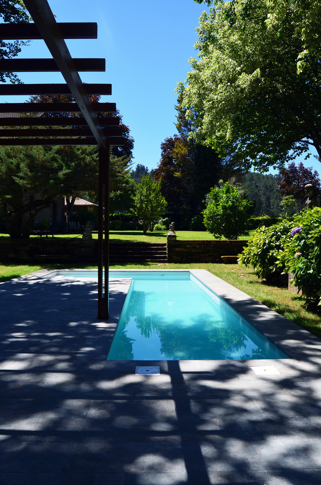 Immagine di una piscina monocorsia country a "L" di medie dimensioni e dietro casa con una dépendance a bordo piscina e piastrelle