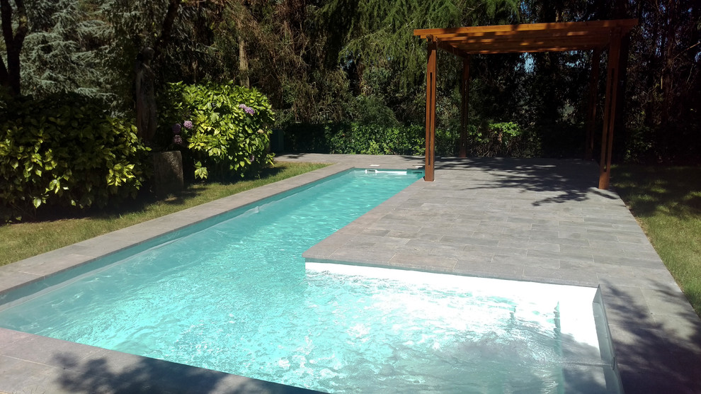 Foto de casa de la piscina y piscina alargada de estilo de casa de campo de tamaño medio en forma de L en patio trasero con suelo de baldosas