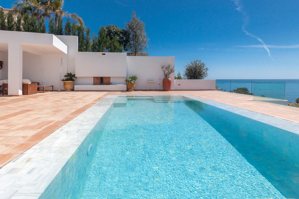 Modelo de casa de la piscina y piscina alargada costera de tamaño medio rectangular en patio delantero