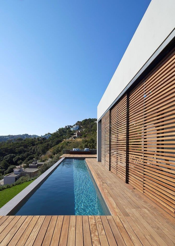 Immagine di una piccola piscina monocorsia moderna a "L" davanti casa con una dépendance a bordo piscina