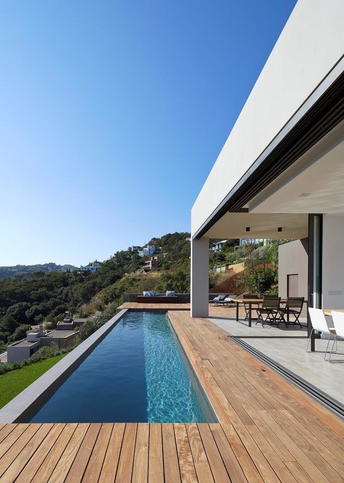 Cette image montre un petit couloir de nage minimaliste en L avec une terrasse en bois.