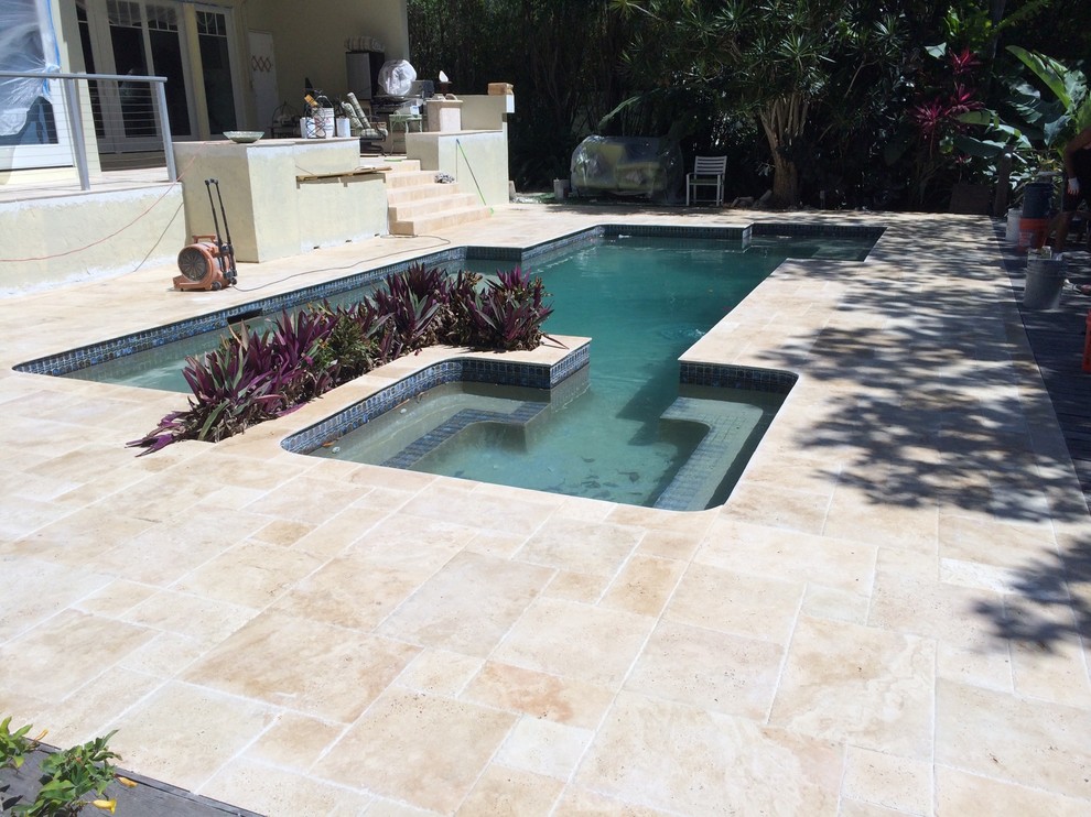 Foto di una piscina naturale moderna personalizzata di medie dimensioni e dietro casa con pavimentazioni in pietra naturale