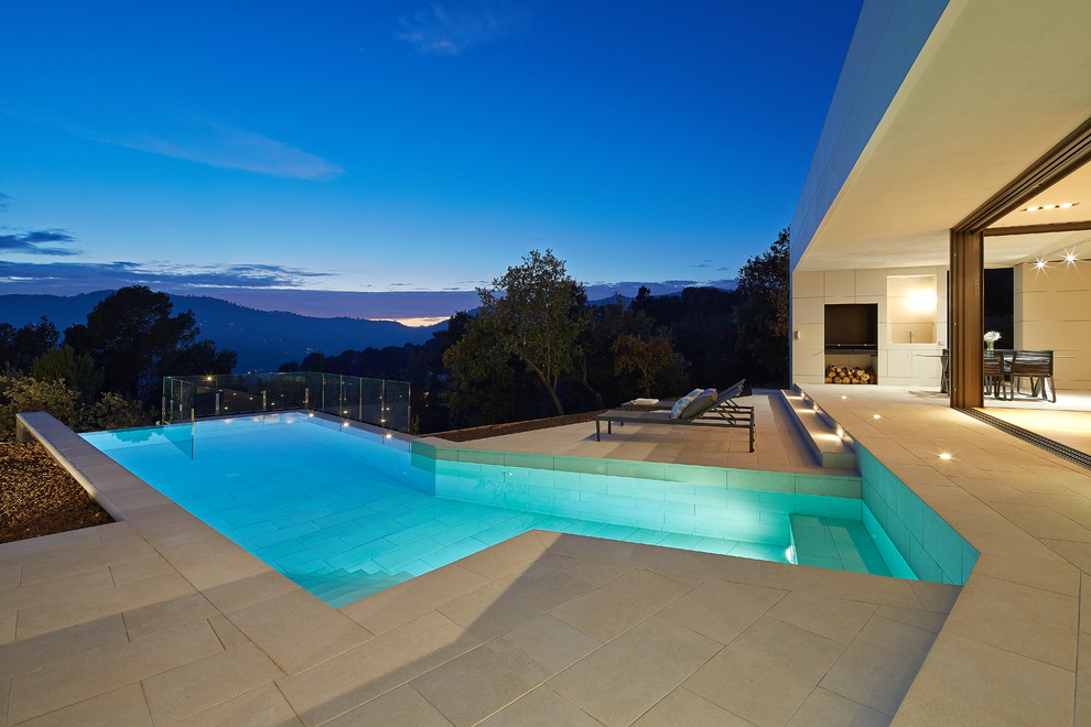 Modelo de casa de la piscina y piscina infinita contemporánea de tamaño medio rectangular en patio delantero