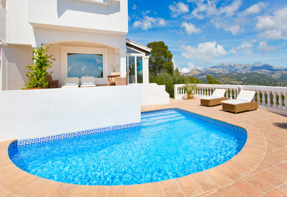 Ejemplo de piscina mediterránea de tamaño medio a medida en patio trasero con suelo de baldosas