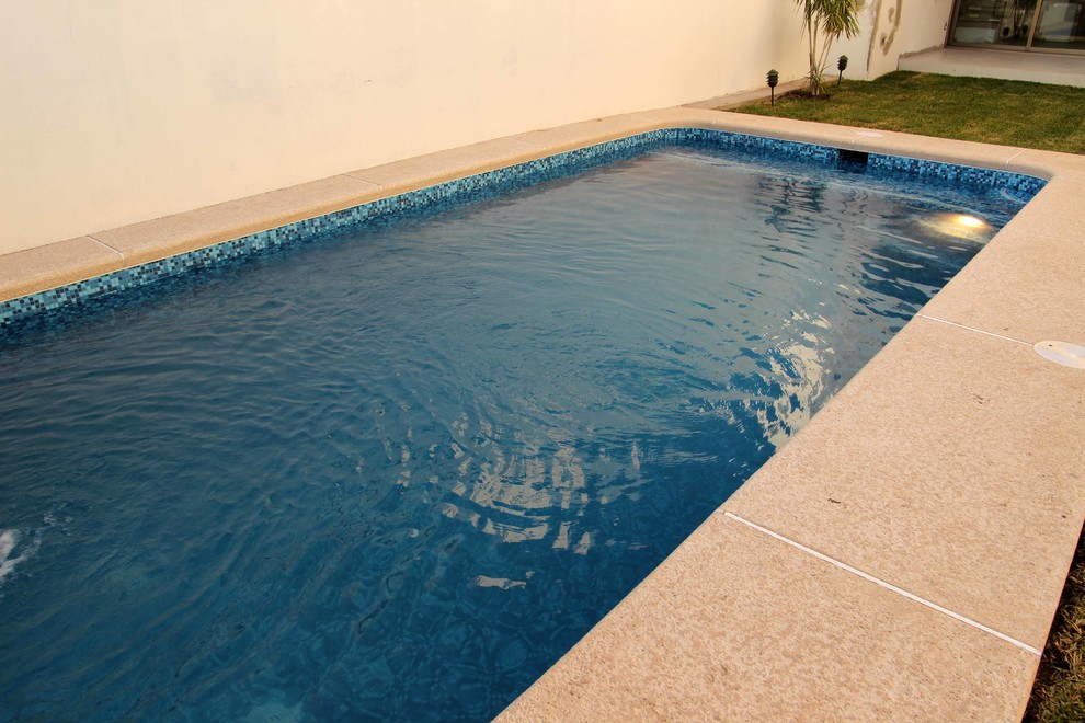Esempio di una piccola piscina monocorsia contemporanea rettangolare dietro casa con fontane