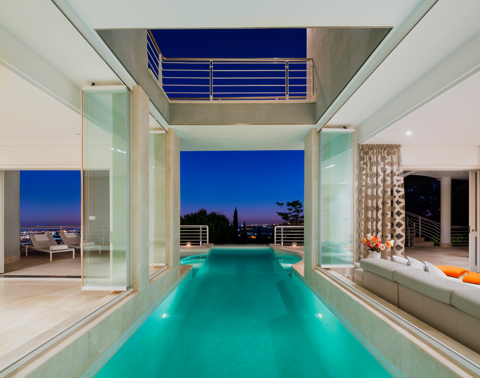 Стильный дизайн: прямоугольный бассейн-инфинити на внутреннем дворе в современном стиле с домиком у бассейна - последний тренд