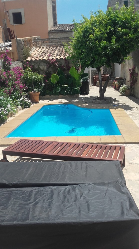 Modelo de casa de la piscina y piscina alargada mediterránea pequeña rectangular en patio delantero con suelo de baldosas