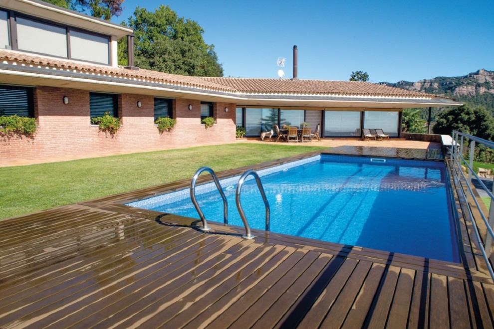 Idée de décoration pour une piscine avant champêtre de taille moyenne et rectangle avec une terrasse en bois.