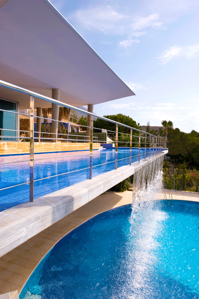 Aménagement d'une piscine à débordement méditerranéenne avec un point d'eau.