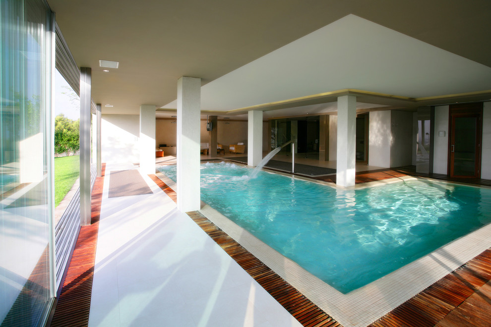 Foto de casa de la piscina y piscina actual grande en forma de L y interior con entablado