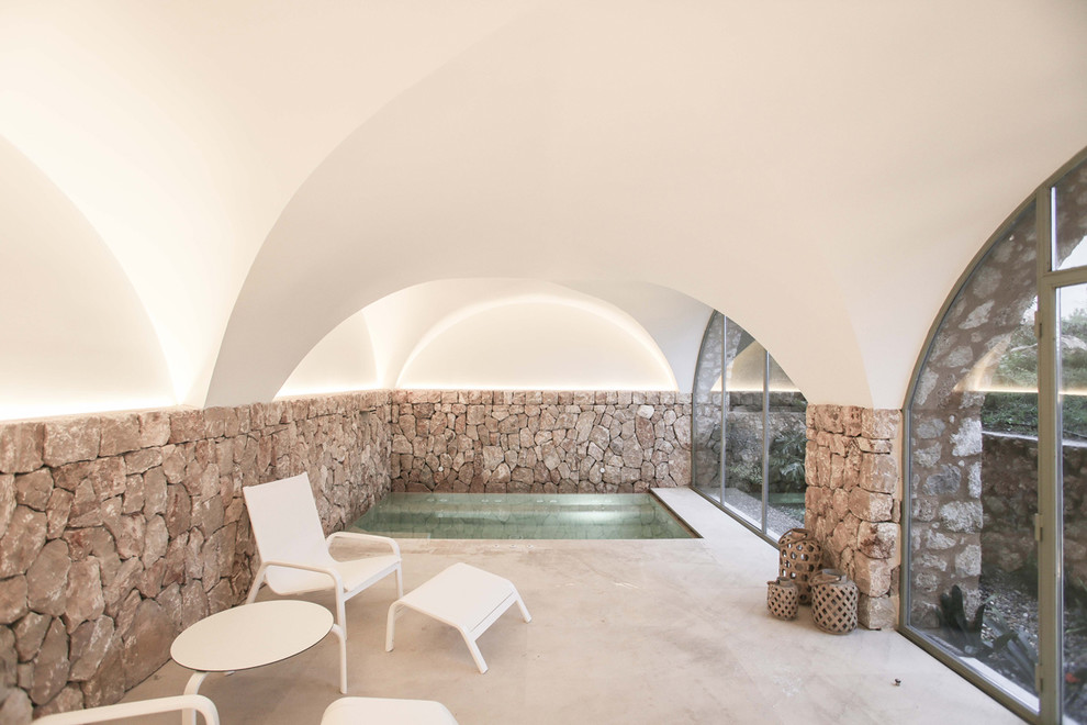 マヨルカ島にある小さな地中海スタイルのおしゃれな屋内プール (コンクリート板舗装	) の写真