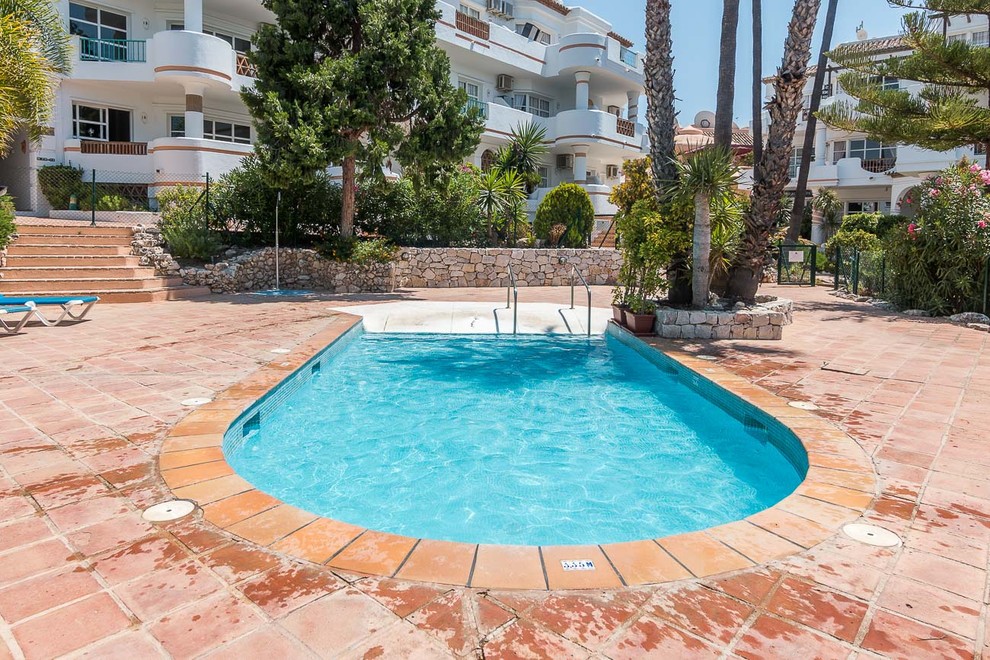 Imagen de piscina alargada mediterránea pequeña rectangular con suelo de baldosas