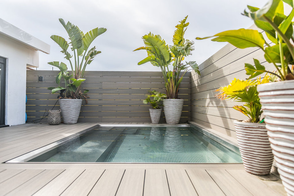 Exemple d'une piscine tendance rectangle avec une terrasse en bois.