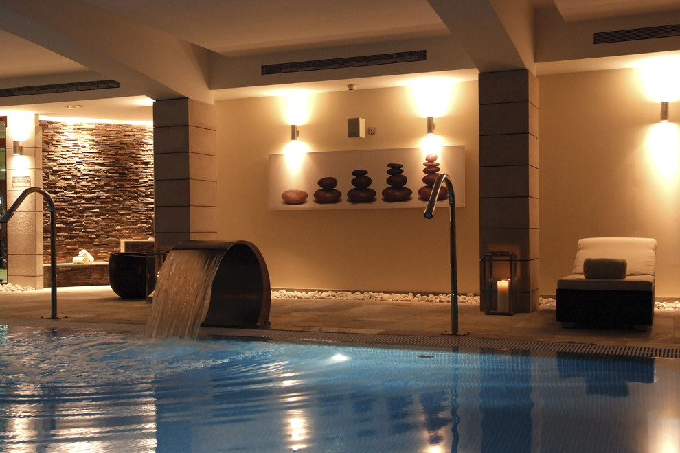 Ejemplo de piscina con fuente alargada exótica de tamaño medio rectangular