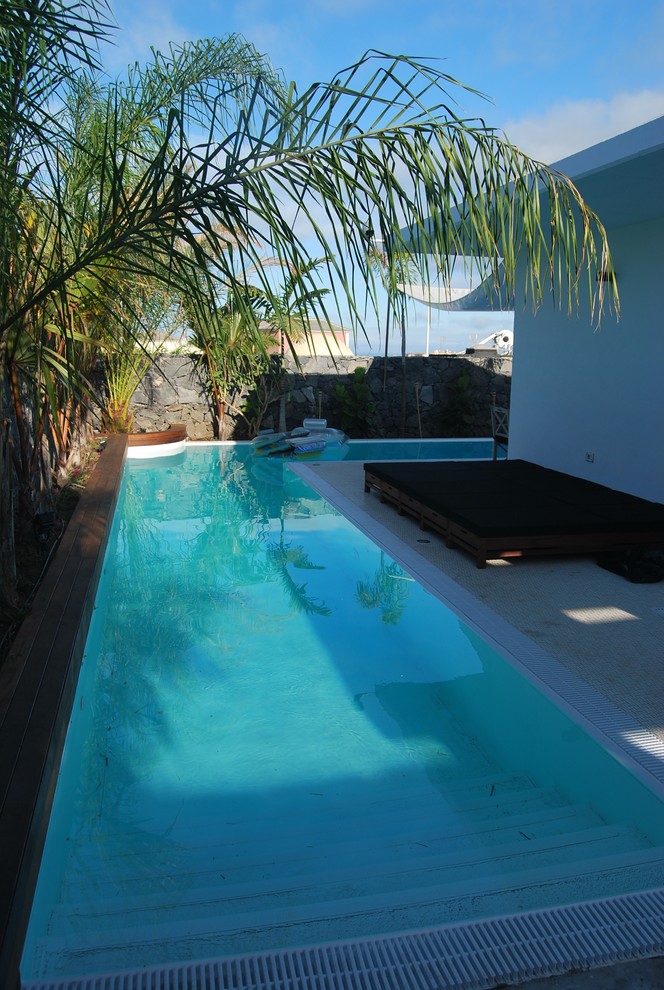 Imagen de casa de la piscina y piscina alargada actual de tamaño medio en forma de L