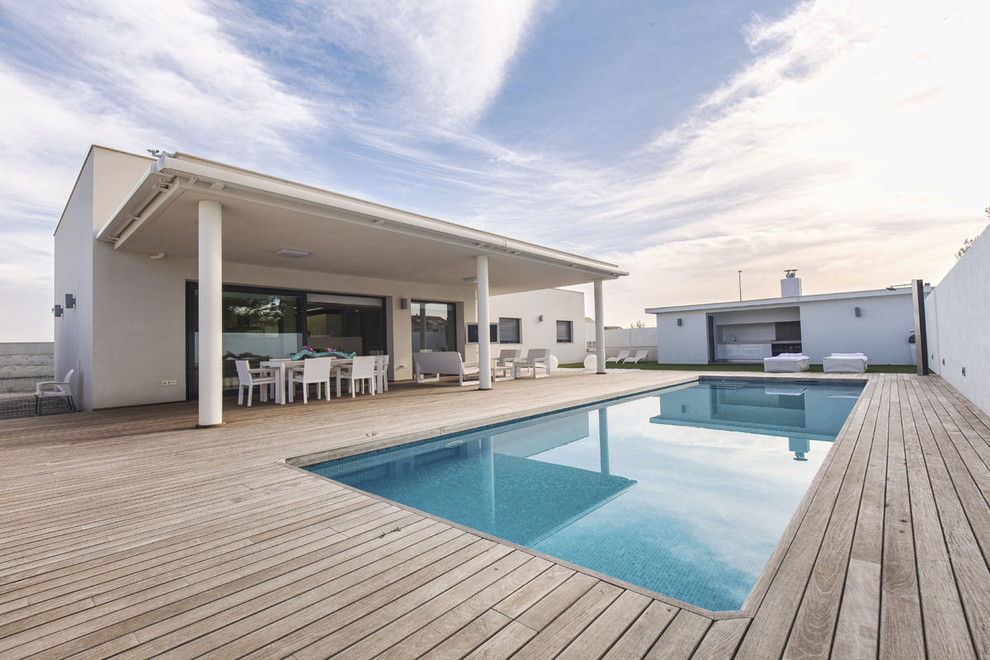 Esempio di una piscina monocorsia minimalista personalizzata di medie dimensioni e in cortile con una dépendance a bordo piscina e pedane