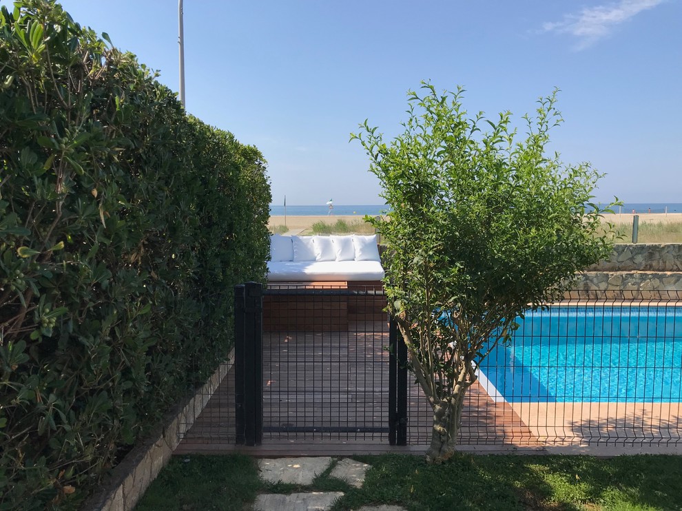 Ejemplo de piscina alargada mediterránea de tamaño medio rectangular en patio delantero