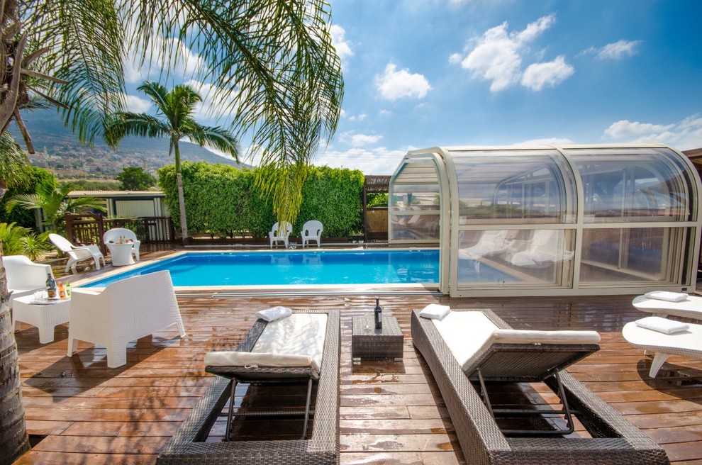 Aménagement d'une piscine contemporaine de taille moyenne et rectangle avec une terrasse en bois.
