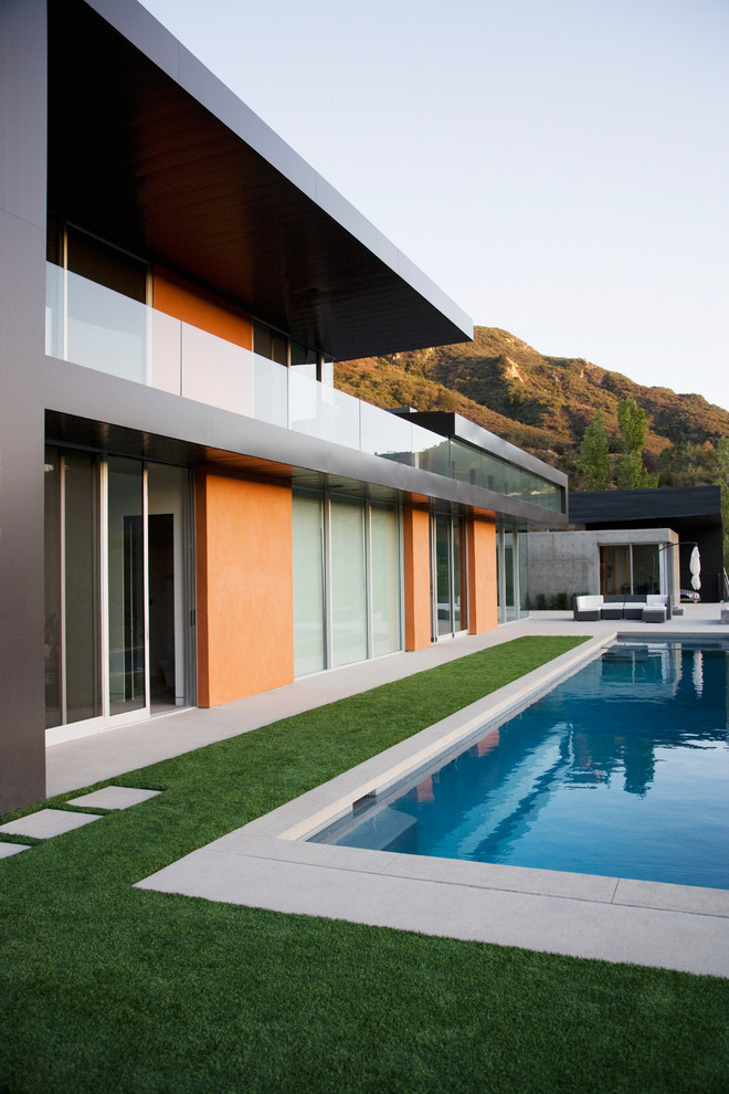 Стильный дизайн: огромный спортивный, прямоугольный бассейн на переднем дворе в современном стиле с джакузи и покрытием из плитки - последний тренд