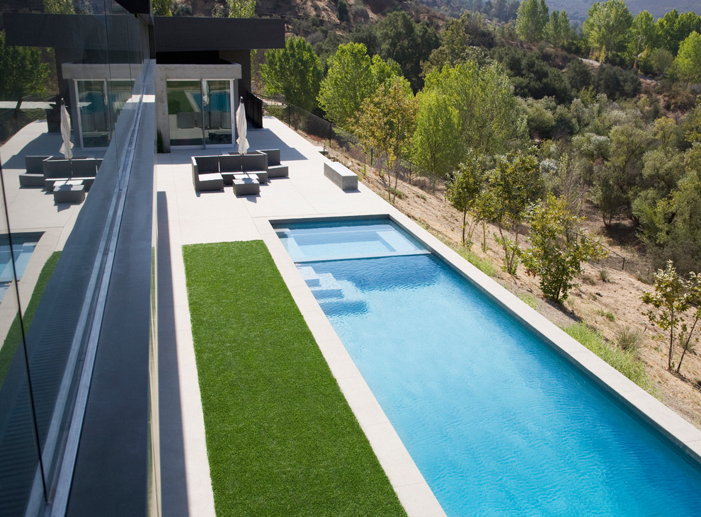 Idee per un'ampia piscina monocorsia design rettangolare davanti casa con una vasca idromassaggio e piastrelle