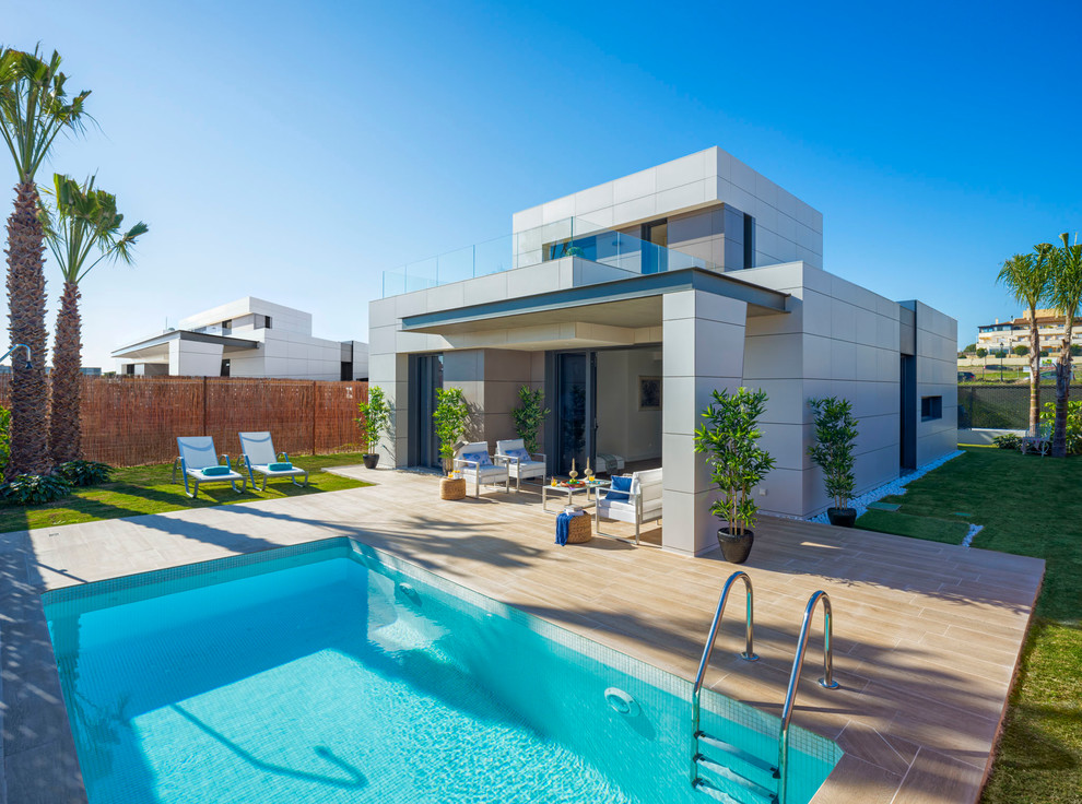Immagine di una piscina monocorsia contemporanea rettangolare di medie dimensioni e dietro casa con una dépendance a bordo piscina e piastrelle