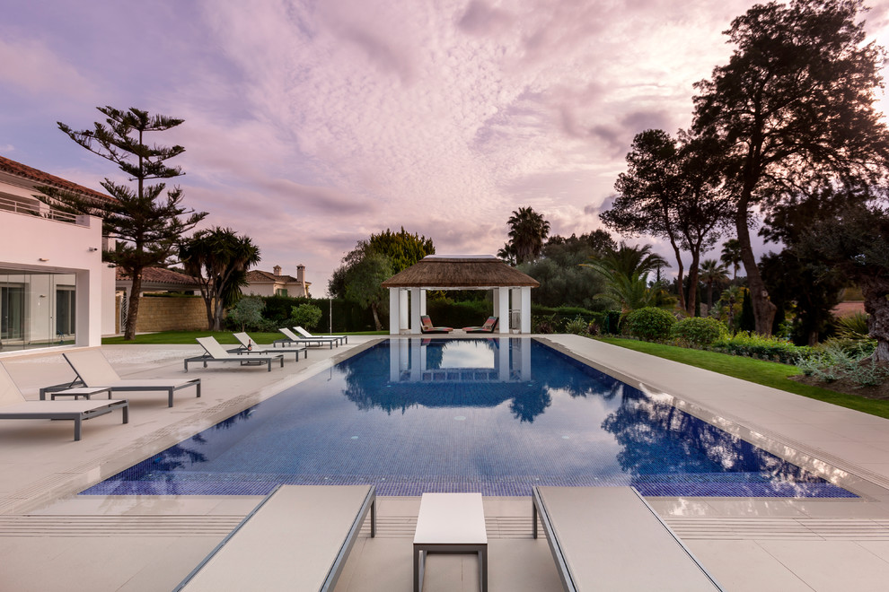 Imagen de casa de la piscina y piscina actual grande rectangular en patio trasero