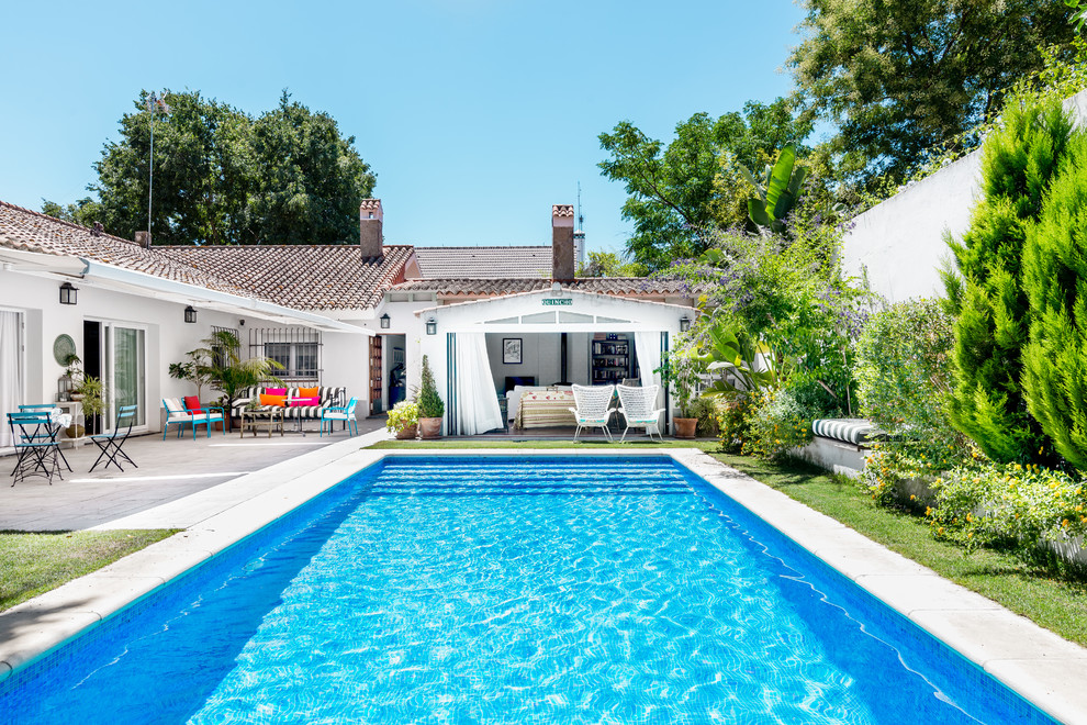 На фото: спортивный, прямоугольный бассейн на заднем дворе в средиземноморском стиле с домиком у бассейна с