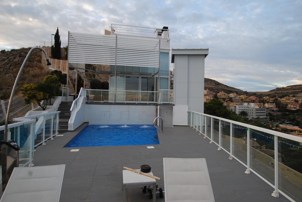 Ispirazione per una piscina monocorsia minimalista rettangolare di medie dimensioni e davanti casa con fontane e piastrelle