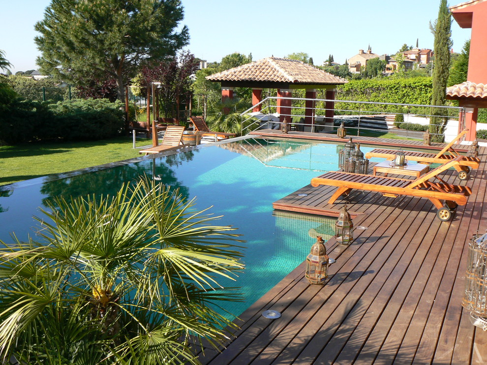 Foto de casa de la piscina y piscina alargada exótica de tamaño medio rectangular en patio delantero con entablado