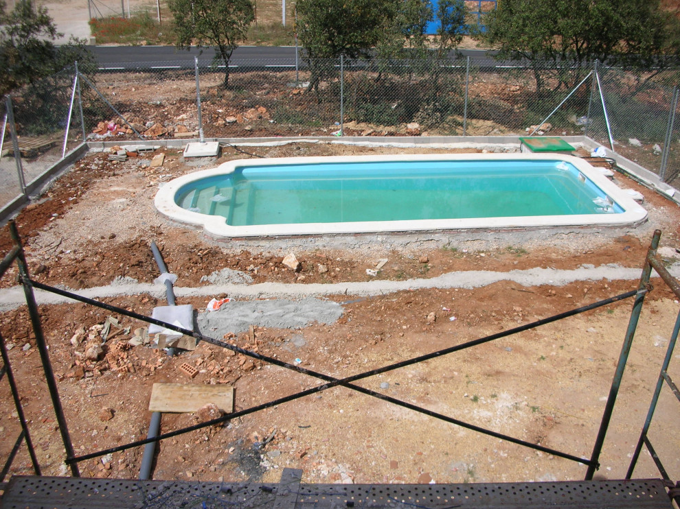 Imagen de piscina alargada moderna de tamaño medio rectangular en patio trasero con paisajismo de piscina y suelo de baldosas