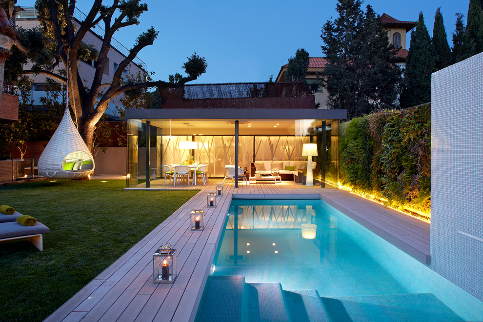 Foto de piscina alargada contemporánea grande rectangular en patio trasero con entablado