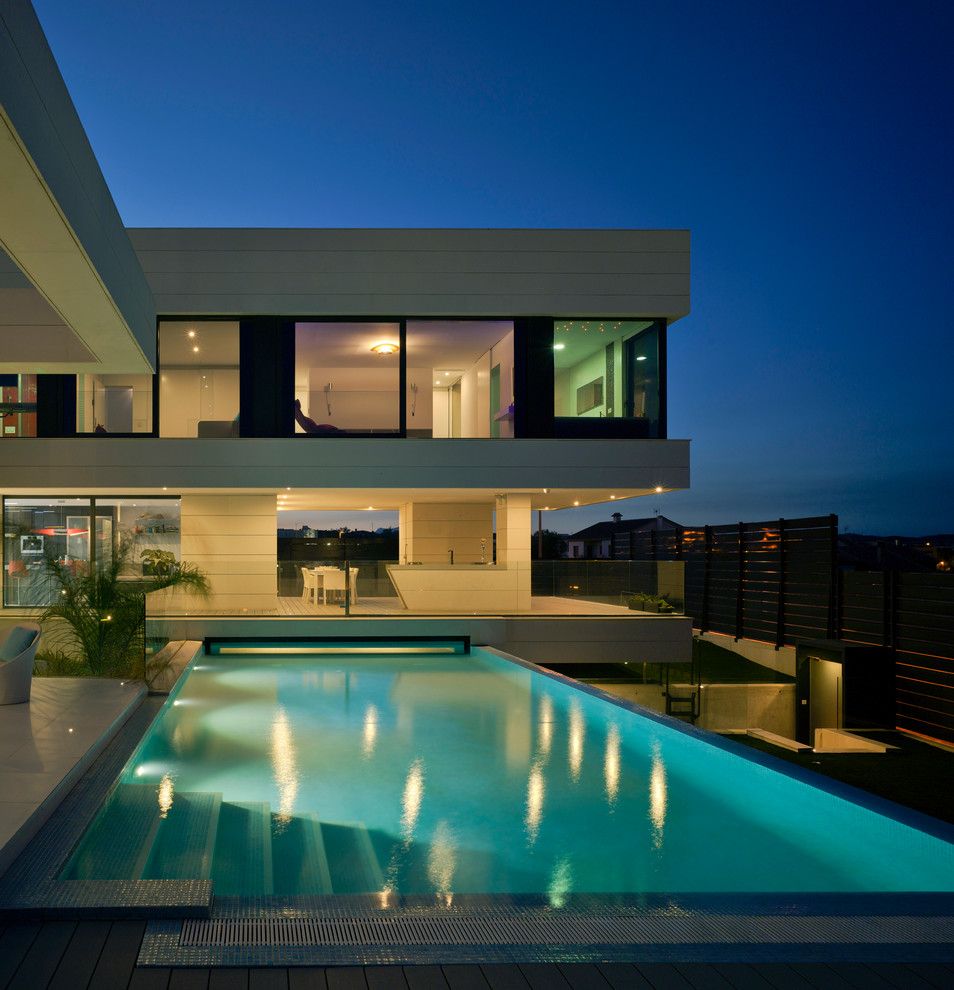 Modelo de casa de la piscina y piscina alargada contemporánea de tamaño medio rectangular en patio